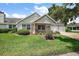 Inviting single-story home featuring a well-kept lawn, covered porch with swing, and attached two-car garage at 911 Beverly Harbors Dr # 16, Leesburg, FL 34748