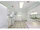 Well-lit kitchen boasts white appliances, cabinets, and tile flooring with a view of the rear door and backyard at 911 Beverly Harbors Dr # 16, Leesburg, FL 34748