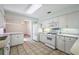 Open kitchen with white appliances and cabinets seamlessly connects to the living room through an eat-in bar area at 911 Beverly Harbors Dr # 16, Leesburg, FL 34748