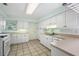 Bright kitchen offering white appliances, cabinetry, tiled floors, and a convenient sink with modern fixtures at 911 Beverly Harbors Dr # 16, Leesburg, FL 34748