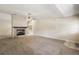 Open living space with fireplace, neutral carpet, and a glimpse into the adjacent kitchen area at 911 Beverly Harbors Dr # 16, Leesburg, FL 34748