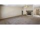 Large living room with cozy fireplace, neutral carpet, and seamless flow to other areas of the home at 911 Beverly Harbors Dr # 16, Leesburg, FL 34748