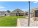 Exterior showcasing the house's backyard, complete with a covered patio, open space, and paved area at 10431 Reagans Run Dr, Clermont, FL 34711