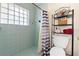 A well-maintained bathroom with glass block window, shower and neutral colors at 10431 Reagans Run Dr, Clermont, FL 34711