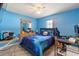 Bedroom with blue walls, fan, tile floors, and natural light at 10431 Reagans Run Dr, Clermont, FL 34711
