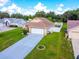 Aerial view of a charming house with a well-kept lawn, long driveway and flower beds at 10431 Reagans Run Dr, Clermont, FL 34711