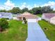 Well-maintained home with a long driveway, lush lawn, and colorful landscaping at 10431 Reagans Run Dr, Clermont, FL 34711