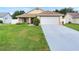 Charming single-story home with a well-maintained lawn, inviting curb appeal, and an attached two-car garage at 10431 Reagans Run Dr, Clermont, FL 34711