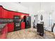 Contemporary kitchen featuring sleek red cabinets, black appliances, and an adjacent dining area, perfect for cooking at 10431 Reagans Run Dr, Clermont, FL 34711