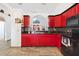 Bright kitchen boasts red cabinets, modern appliances, and granite countertops, offering a blend of style and functionality at 10431 Reagans Run Dr, Clermont, FL 34711