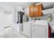 Spacious laundry room with washer, dryer, utility sink, and tile flooring at 10431 Reagans Run Dr, Clermont, FL 34711