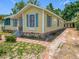 Yellow cottage style home with lovely blue shutters and long driveway at 1109 Edmonds St, Leesburg, FL 34748