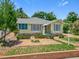 Inviting yellow home with brick accents, lush lawn, and well-maintained landscaping at 1109 Edmonds St, Leesburg, FL 34748