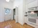 Kitchen area with white appliances, door and hardwood floors at 1109 Edmonds St, Leesburg, FL 34748
