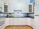 Bright kitchen with white cabinets, black countertops, modern appliances, and hardwood flooring at 1109 Edmonds St, Leesburg, FL 34748