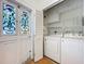 Convenient laundry room with washer, dryer, shelving, and exterior access door at 1109 Edmonds St, Leesburg, FL 34748