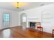 Bright living room boasts hardwood floors, a fireplace, and a view into an adjacent room at 1109 Edmonds St, Leesburg, FL 34748