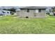 A view of the green back yard with a siding on the home at 117 Jacaranda Dr, Leesburg, FL 34748