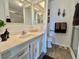 Bright bathroom featuring a single sink vanity, decorative mirrors, a toilet, and a walk-in shower at 117 Jacaranda Dr, Leesburg, FL 34748