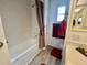 Bright bathroom featuring a tub/shower combo with neutral decor and ample natural light from the window at 117 Jacaranda Dr, Leesburg, FL 34748