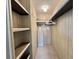 Well-organized walk-in closet featuring custom shelving, and an ironing board at 117 Jacaranda Dr, Leesburg, FL 34748