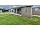 Home exterior with a covered patio and a lush green lawn at 117 Jacaranda Dr, Leesburg, FL 34748
