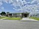 Charming single-story home featuring a carport, well-maintained lawn, and inviting curb appeal on a sunny day at 117 Jacaranda Dr, Leesburg, FL 34748