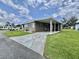 Charming single-story home with a carport, bright windows, and an expansive driveway and front yard at 117 Jacaranda Dr, Leesburg, FL 34748