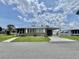 Charming single-story home featuring a carport, well-maintained lawn, and inviting curb appeal on a sunny day at 117 Jacaranda Dr, Leesburg, FL 34748