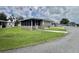Exterior featuring a screened-in porch and a tidy, grassy yard at 117 Jacaranda Dr, Leesburg, FL 34748