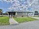 Front view of the home, with screened-in porch and walkway at 117 Jacaranda Dr, Leesburg, FL 34748
