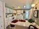 Well-lit kitchen with white cabinets, laminate countertops and peninsula with bar stool seating at 117 Jacaranda Dr, Leesburg, FL 34748