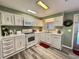Well-maintained kitchen with white cabinetry, modern appliances, and durable laminate flooring at 117 Jacaranda Dr, Leesburg, FL 34748