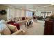 Comfortable living room featuring plush seating, a ceiling fan, and large windows with white blinds at 117 Jacaranda Dr, Leesburg, FL 34748