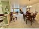 Open concept living and dining area with dining table, chandelier, neutral paint, and plush carpeting at 117 Jacaranda Dr, Leesburg, FL 34748
