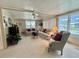 Bright living room with a ceiling fan, comfortable seating, and large windows offering natural light at 117 Jacaranda Dr, Leesburg, FL 34748