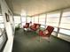 Cozy sun room with comfortable seating and abundant natural light streaming through the screened windows at 117 Jacaranda Dr, Leesburg, FL 34748