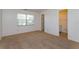 Bedroom featuring neutral carpet, natural light from window, and an attached bathroom at 12 Windtree Ln # 202, Winter Garden, FL 34787