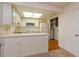 Bright kitchen featuring white cabinets, countertops, skylight, modern appliances, and wood-look floor at 12 Windtree Ln # 202, Winter Garden, FL 34787