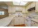Bright kitchen with white cabinetry, laminate countertops, stainless sink and white appliances at 12 Windtree Ln # 202, Winter Garden, FL 34787