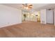 Open living room with plush carpet, mirrored wall, ceiling fan, and view of the eat in kitchen at 12 Windtree Ln # 202, Winter Garden, FL 34787