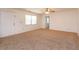 Neutral living room offering plush carpet, ceiling fan and access to multiple rooms at 12 Windtree Ln # 202, Winter Garden, FL 34787
