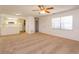 Spacious carpeted living room flowing into kitchen area featuring a ceiling fan, large window at 12 Windtree Ln # 202, Winter Garden, FL 34787