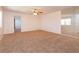 Bright living room featuring plush carpet, a ceiling fan, and a mirrored wall to enhance space at 12 Windtree Ln # 202, Winter Garden, FL 34787