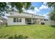 Spacious backyard featuring a covered patio with seating and a well-maintained lawn at 12120 Sumter Dr, Orlando, FL 32824