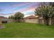 Fenced backyard with lush green grass, trees, and space for outdoor activities at 12120 Sumter Dr, Orlando, FL 32824
