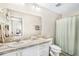 This standard bathroom has a large mirror, neutral walls, and a shower curtain covering the shower at 12120 Sumter Dr, Orlando, FL 32824