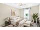 This staged bedroom is brightly lit, with a neutral palette and a view of a lake out the window at 12120 Sumter Dr, Orlando, FL 32824