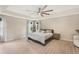 This spacious bedroom features a tray ceiling, large fan, wood floors, and light-colored walls at 12120 Sumter Dr, Orlando, FL 32824