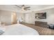 Well-lit bedroom has wood floors, dresser, and a large tv on the wall at 12120 Sumter Dr, Orlando, FL 32824